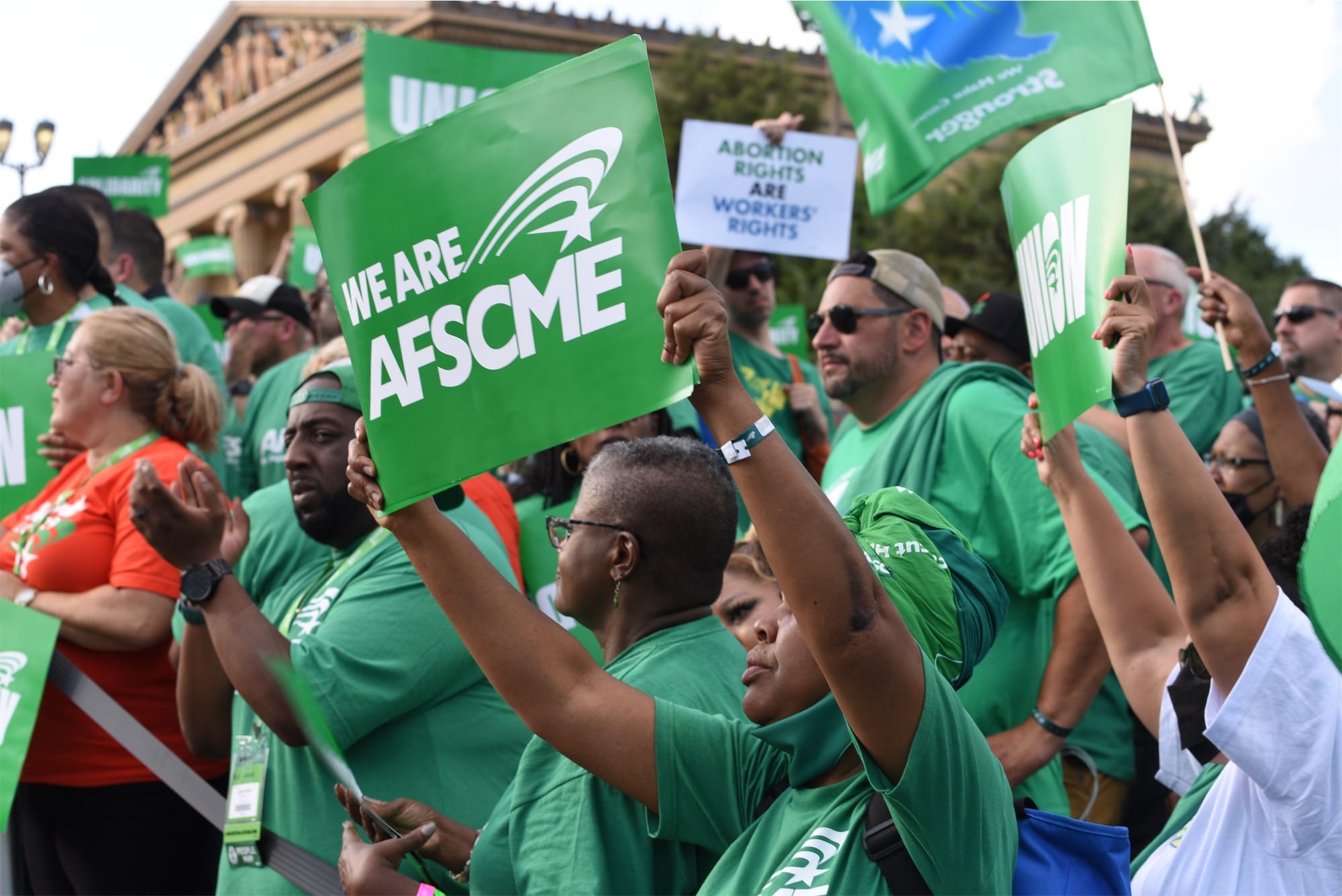 Crowd holding up sign reading "We Are AFSCME"